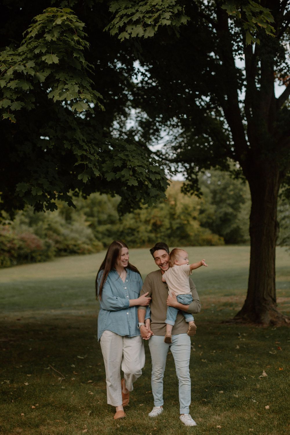 Family of three walking through their backyard during their family lifestyle session.