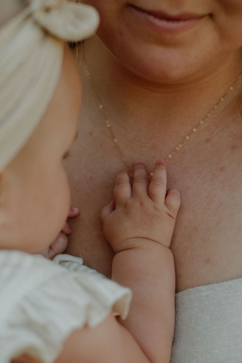 Little details of baby's hand and mom's necklace during family session in Grand Rapids, MI.