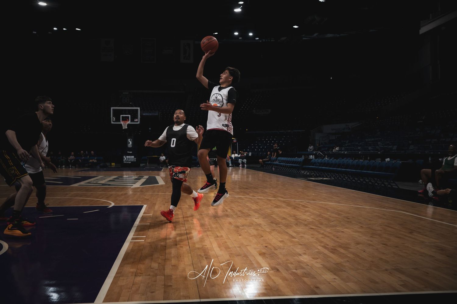 Basketball player soaring through the air for a slam dunk on a purple court.