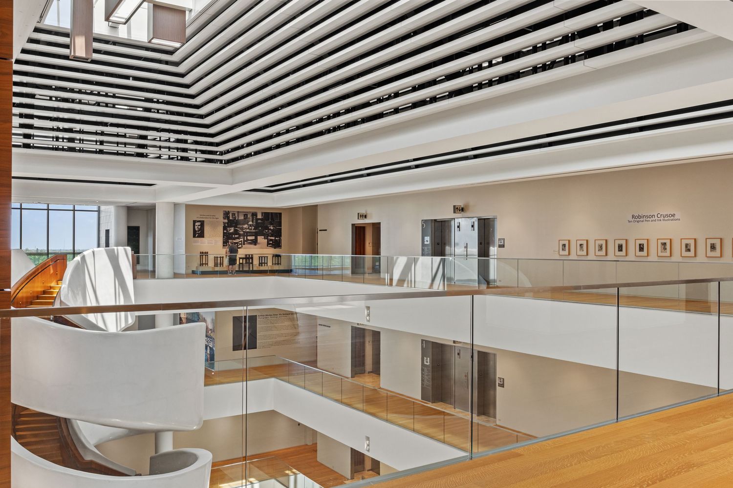 Contemporary museum architecture featuring striped ceiling design and wooden flooring.