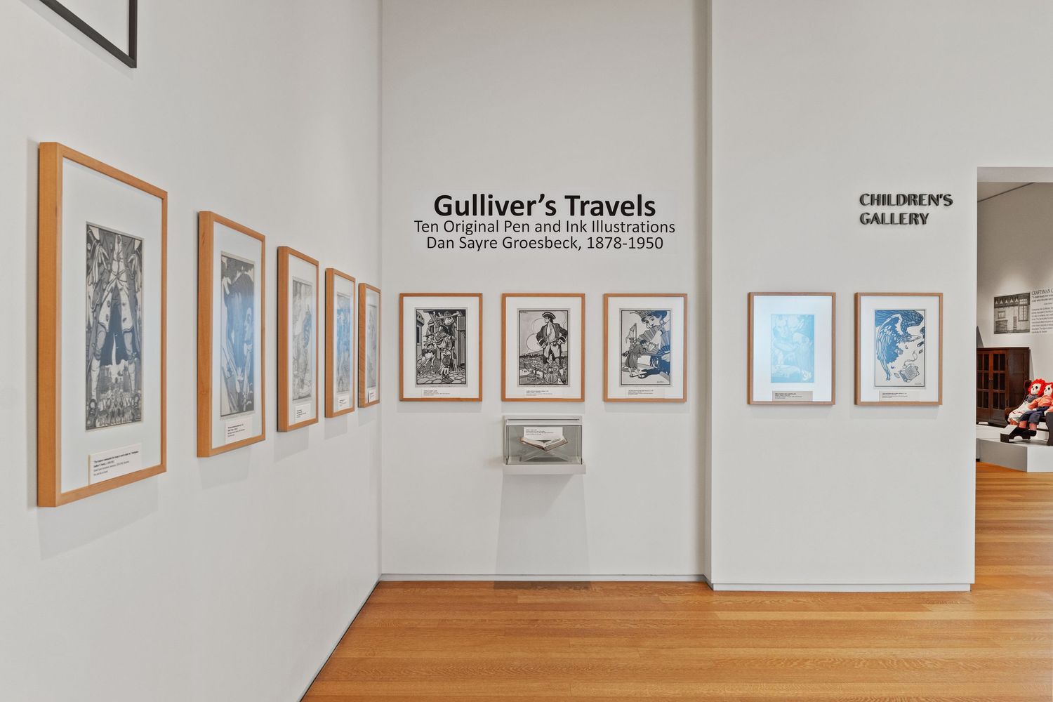 Museum gallery wall displaying Gulliver's Travels artwork collection in matching frames.