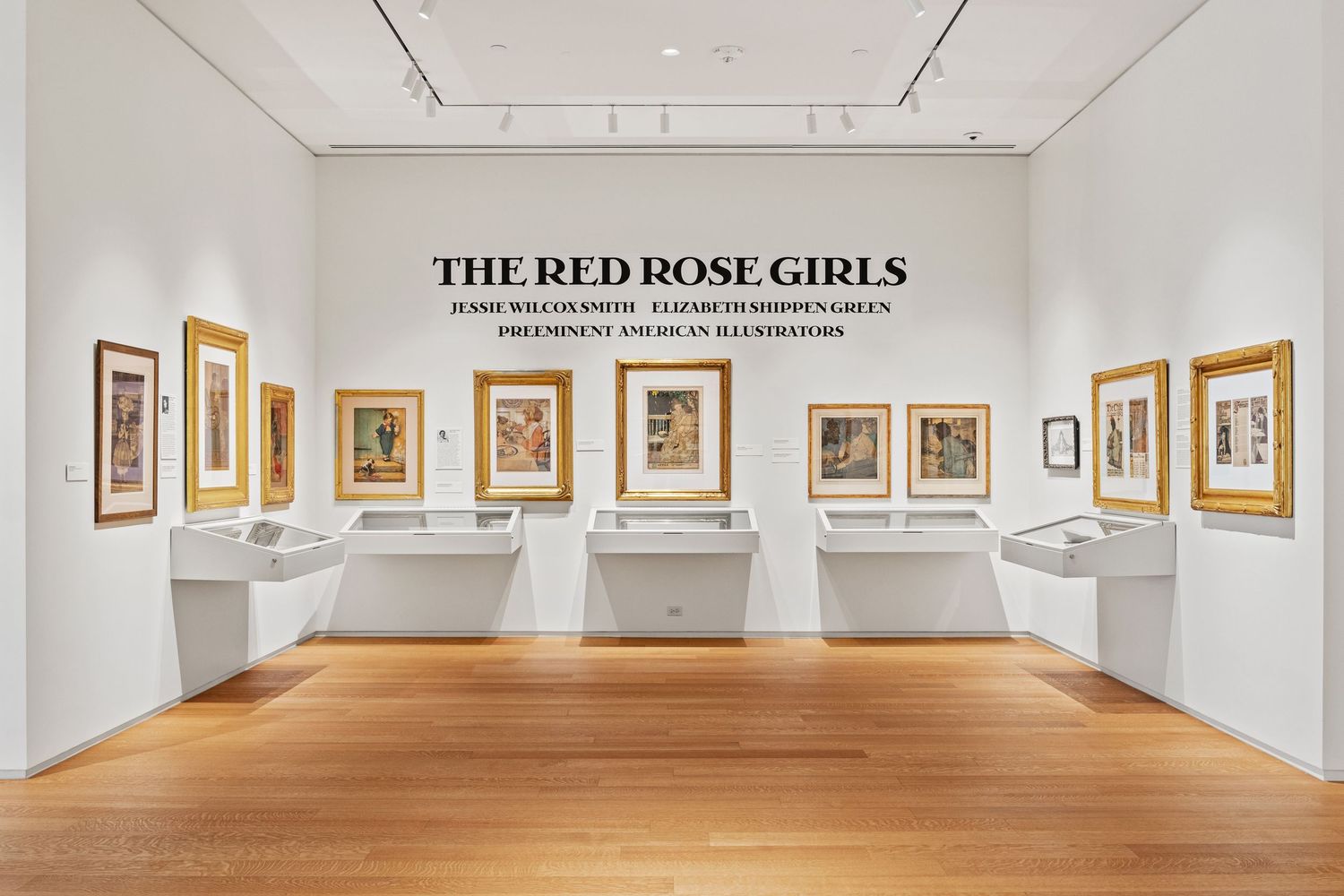 Art gallery exhibition space titled 'The Red Rose Girls' with framed works along white walls.