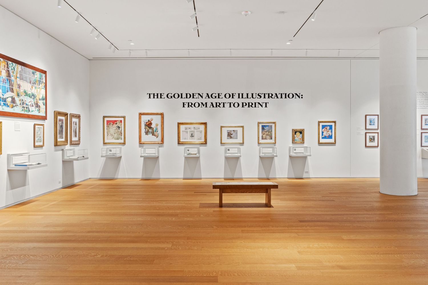 Museum gallery showing 'The Golden Age of Illustration' exhibition with wooden floors and white walls.