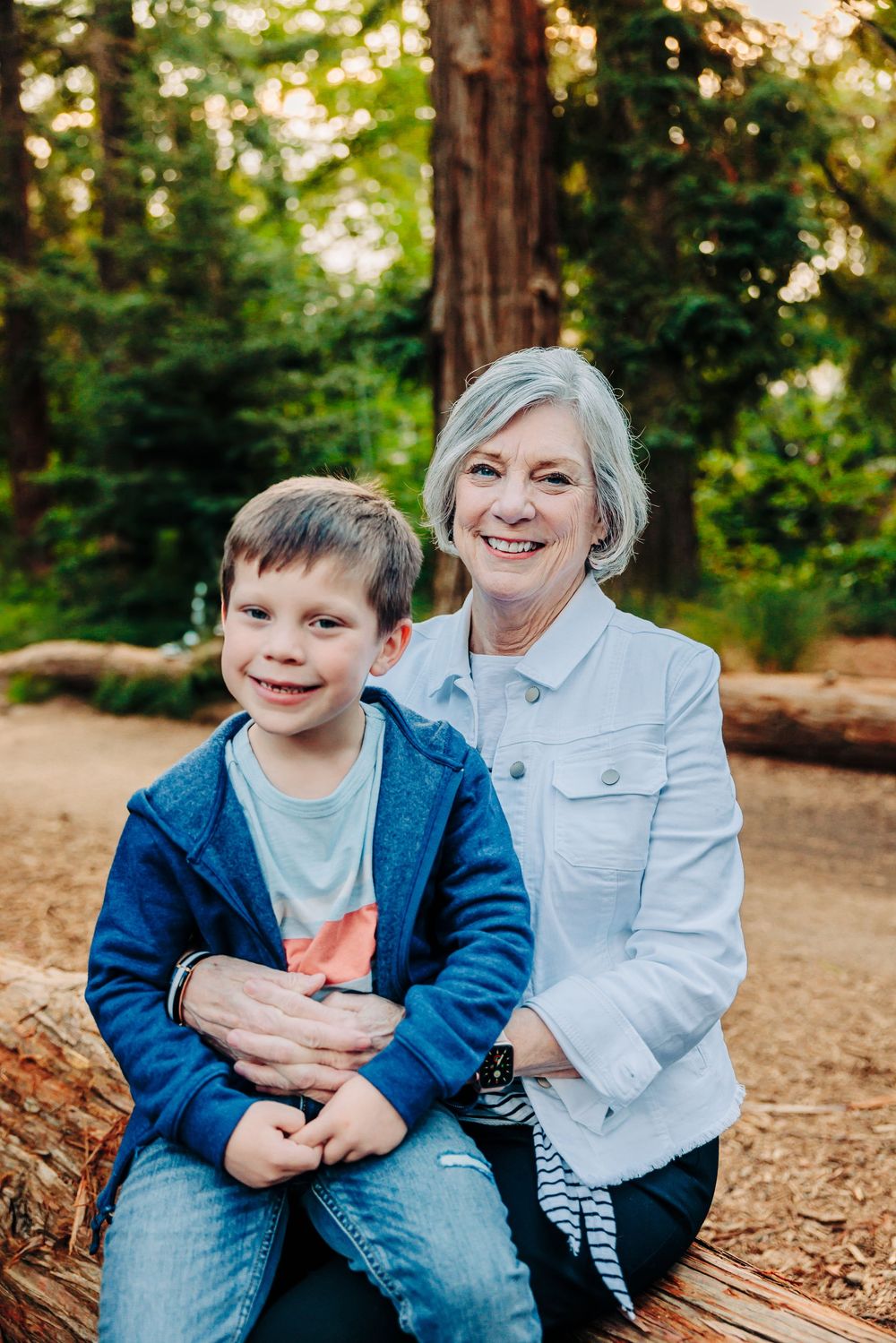 A series of candid outdoor portraits showing joyful moments between two people sitting on fallen logs in a wooded setting.
