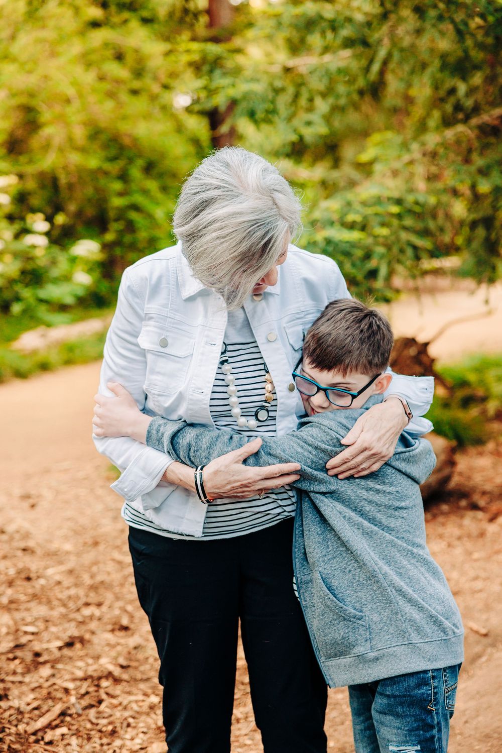 A heartwarming series of embraces between two people in an outdoor setting with autumn foliage in the background.