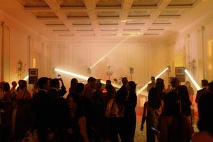 Elegant ballroom dance floor filled with guests dancing under dramatic laser light beams during a lively evening event.