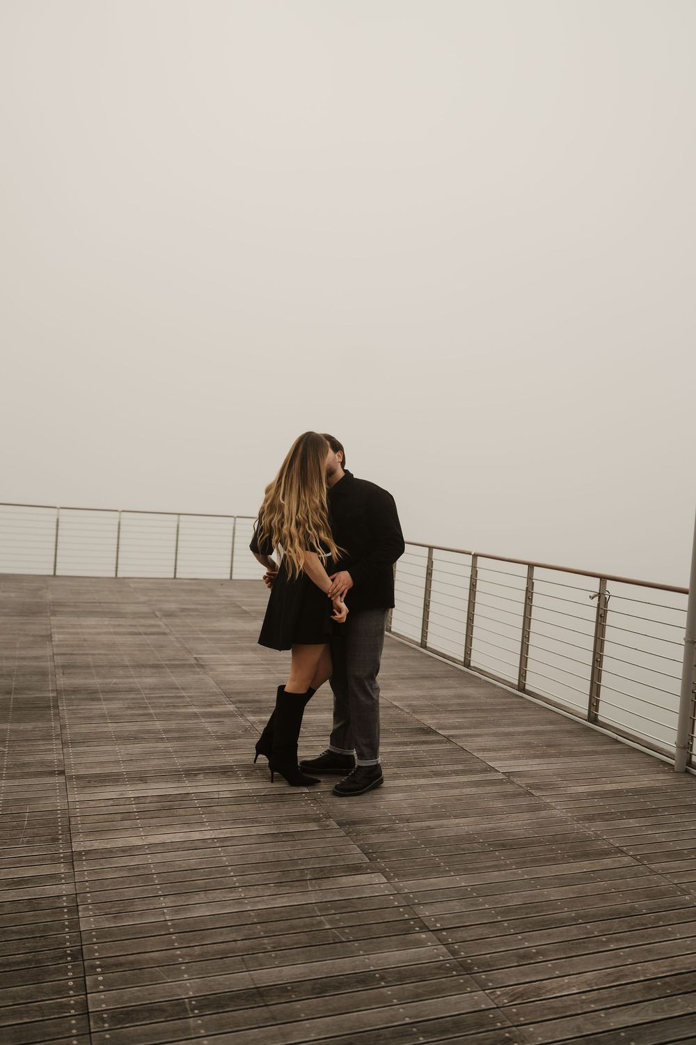 A sweet kiss hidden by the fog, cinematic destination wedding photography in Italy.