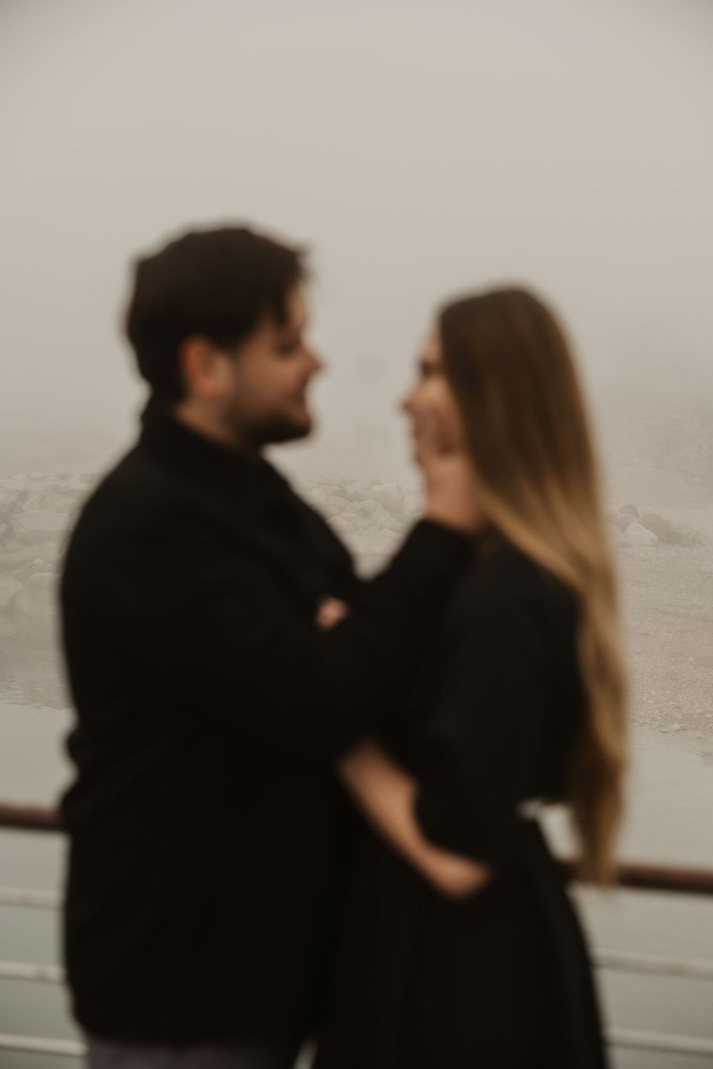 Soft-focus portrait of a romantic international couple in the mist, Portopiccolo photoshoot.