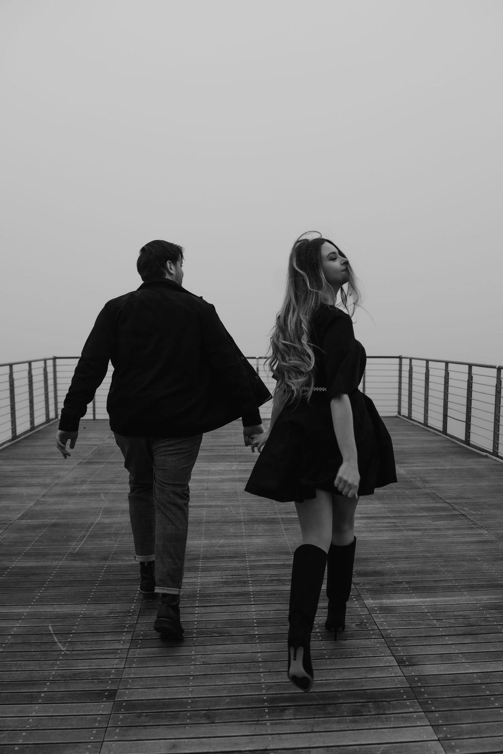 Wide cinematic shot of an elegant couple exploring the quiet corners of Portopiccolo.