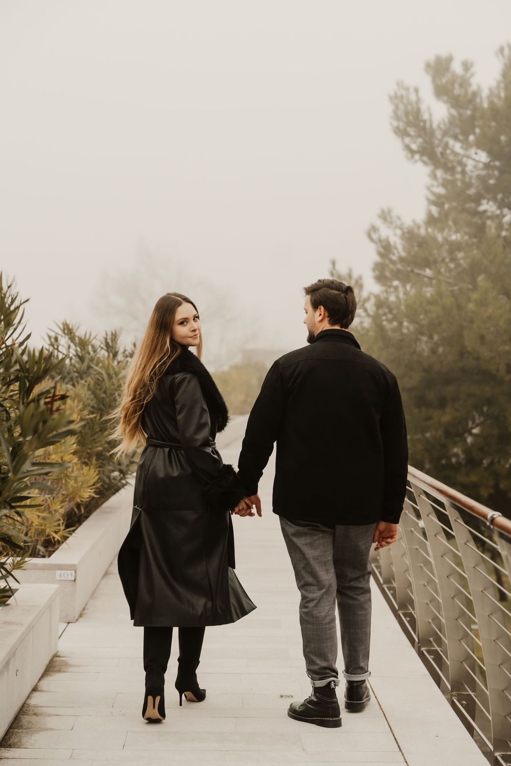 Detail shot of a man's coat around a woman's shoulders, cinematic couple session.