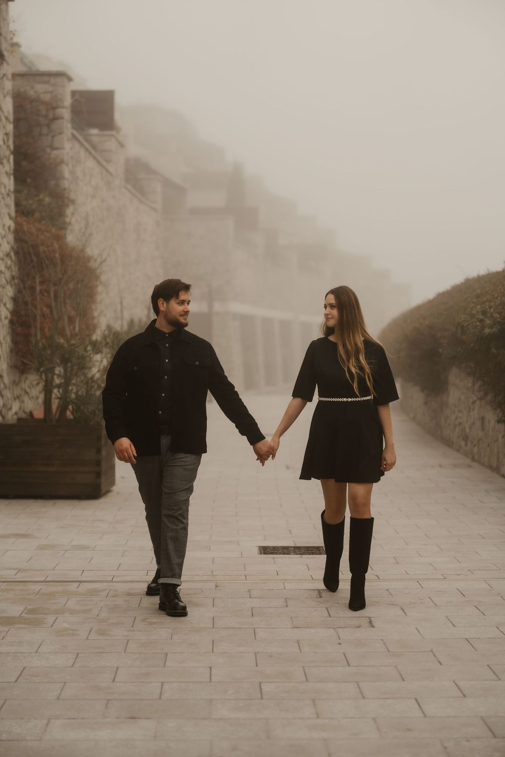 Portopiccolo engagement photographer capturing a candid laugh under a stone archway.