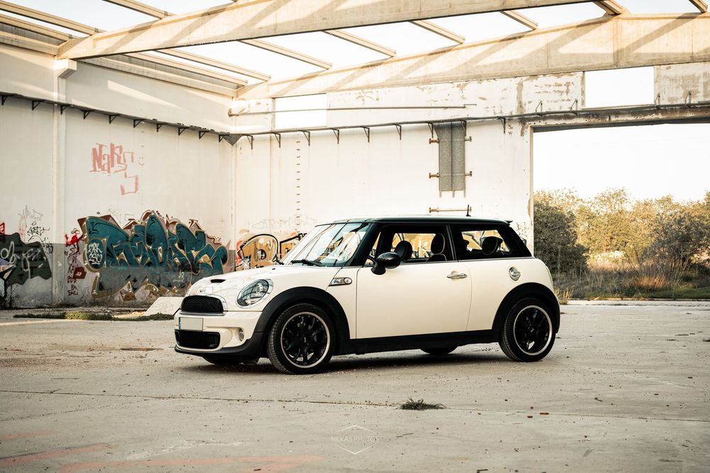 White Mini Cooper parked inside an abandoned building with graffiti walls and black alloy wheels.