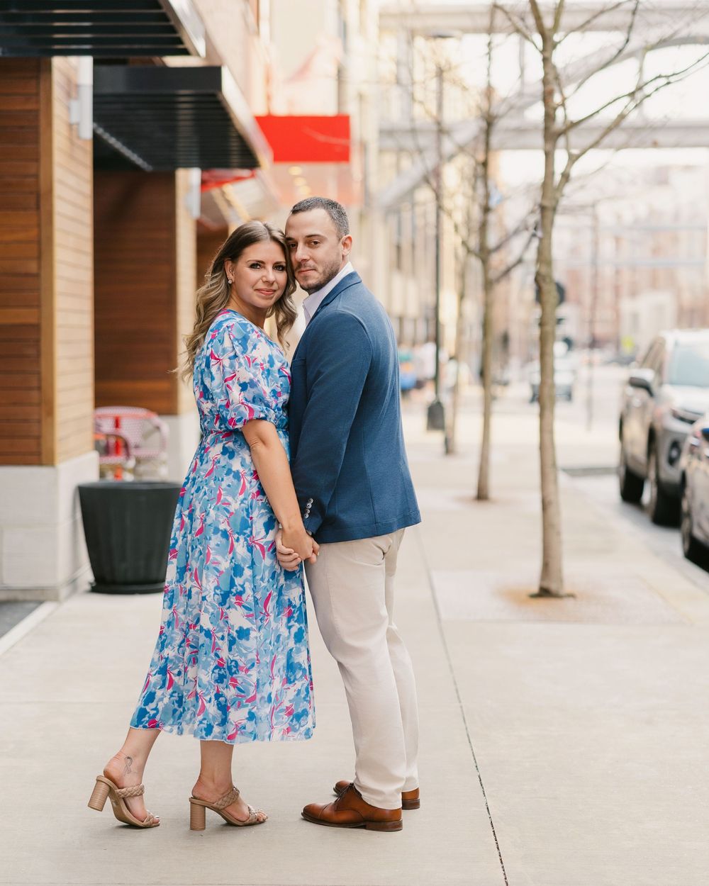Couple posing on urban sidewalk, Engagement session Bridge Park Dublin Ohio.