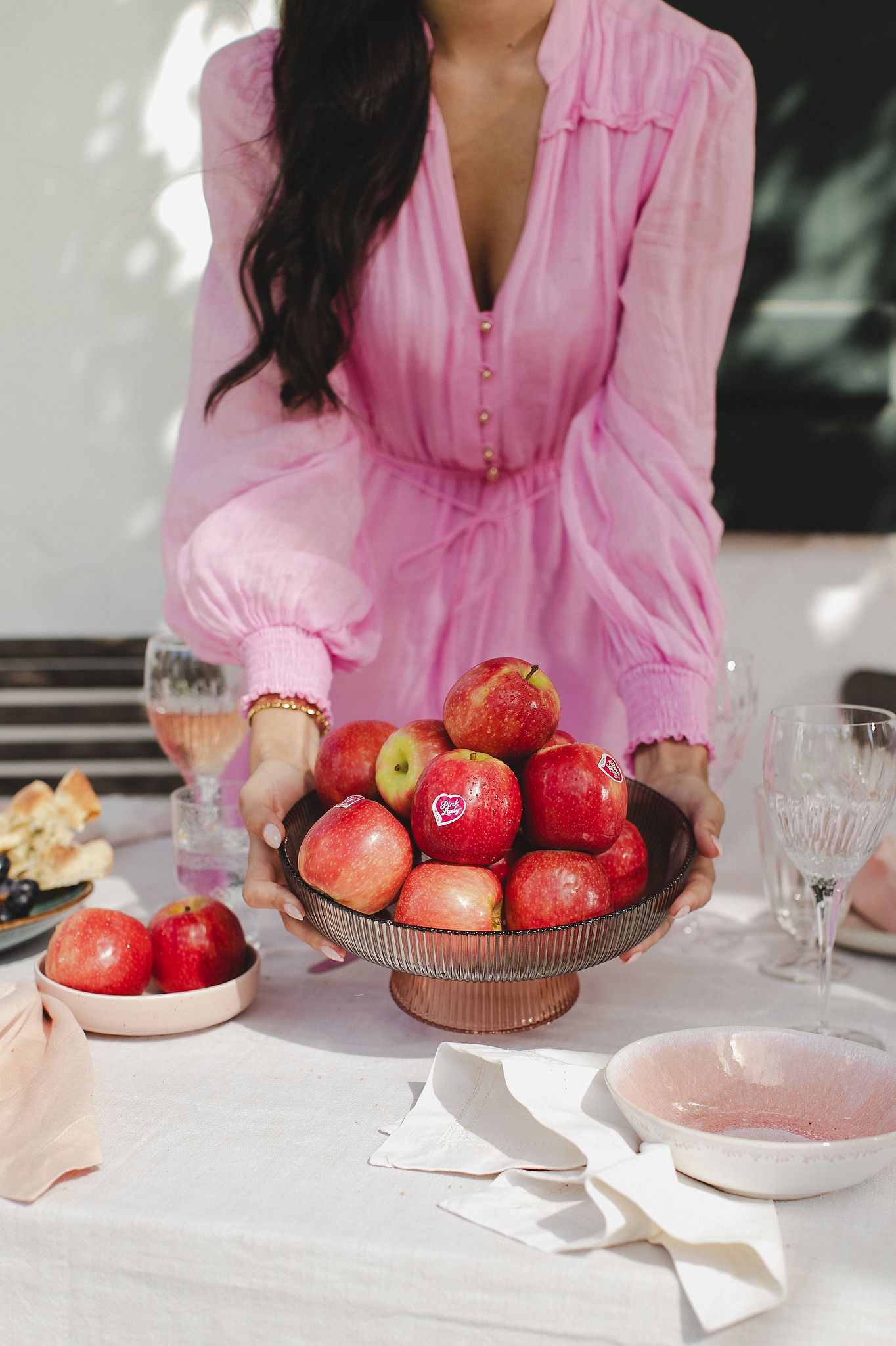 Whole Pink Lady apples scattered on a linen cloth with soft, neutral styling.