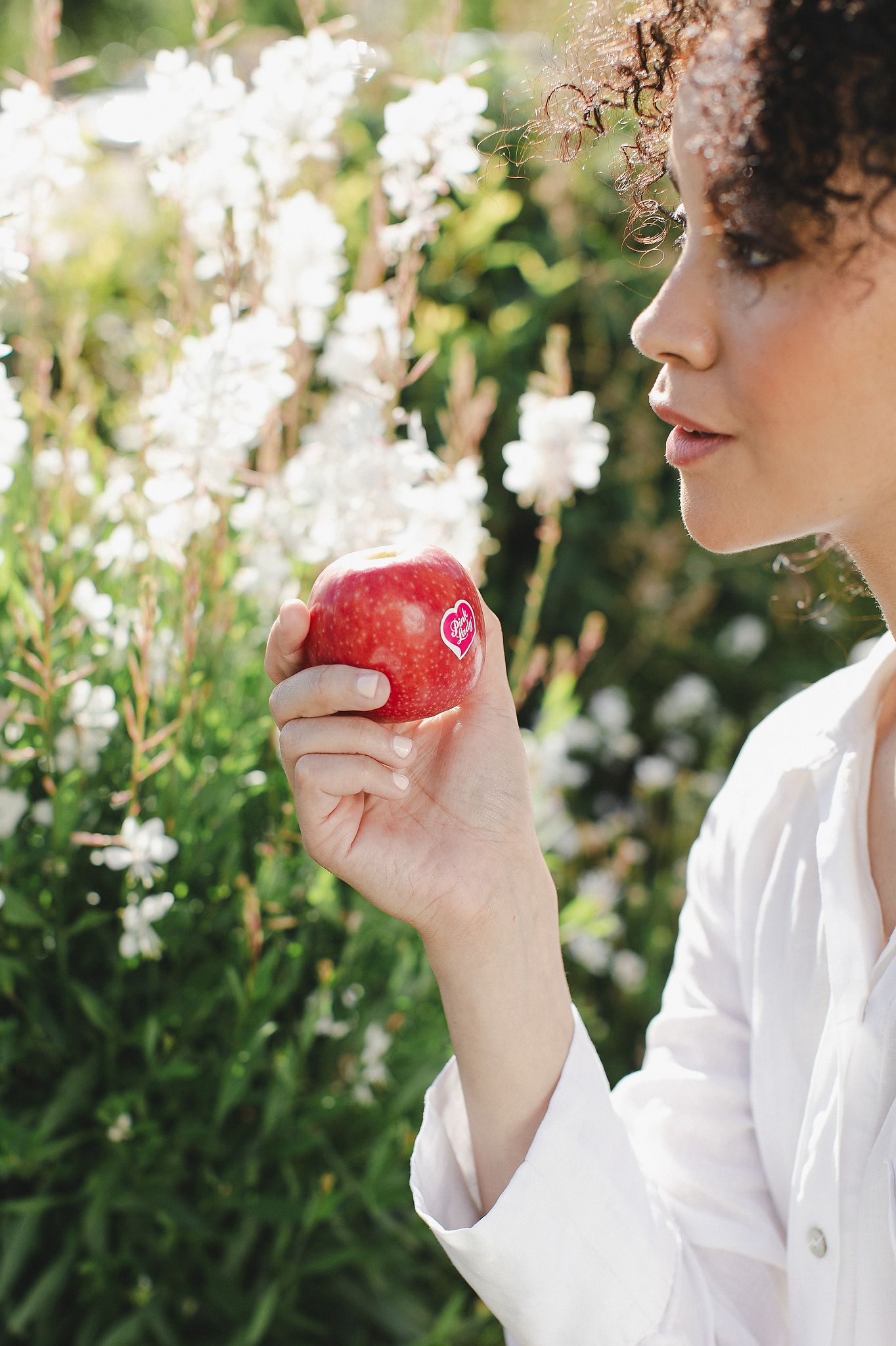 Close-up of a Pink Lady apple with water droplets highlighting its crisp freshness.
