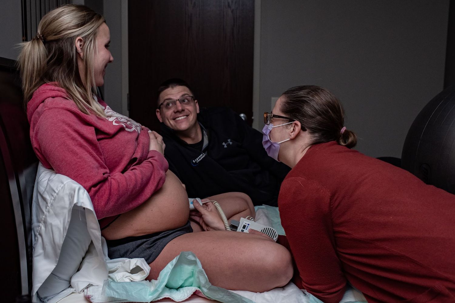 Medical staff attending to patient during labor in hospital room.