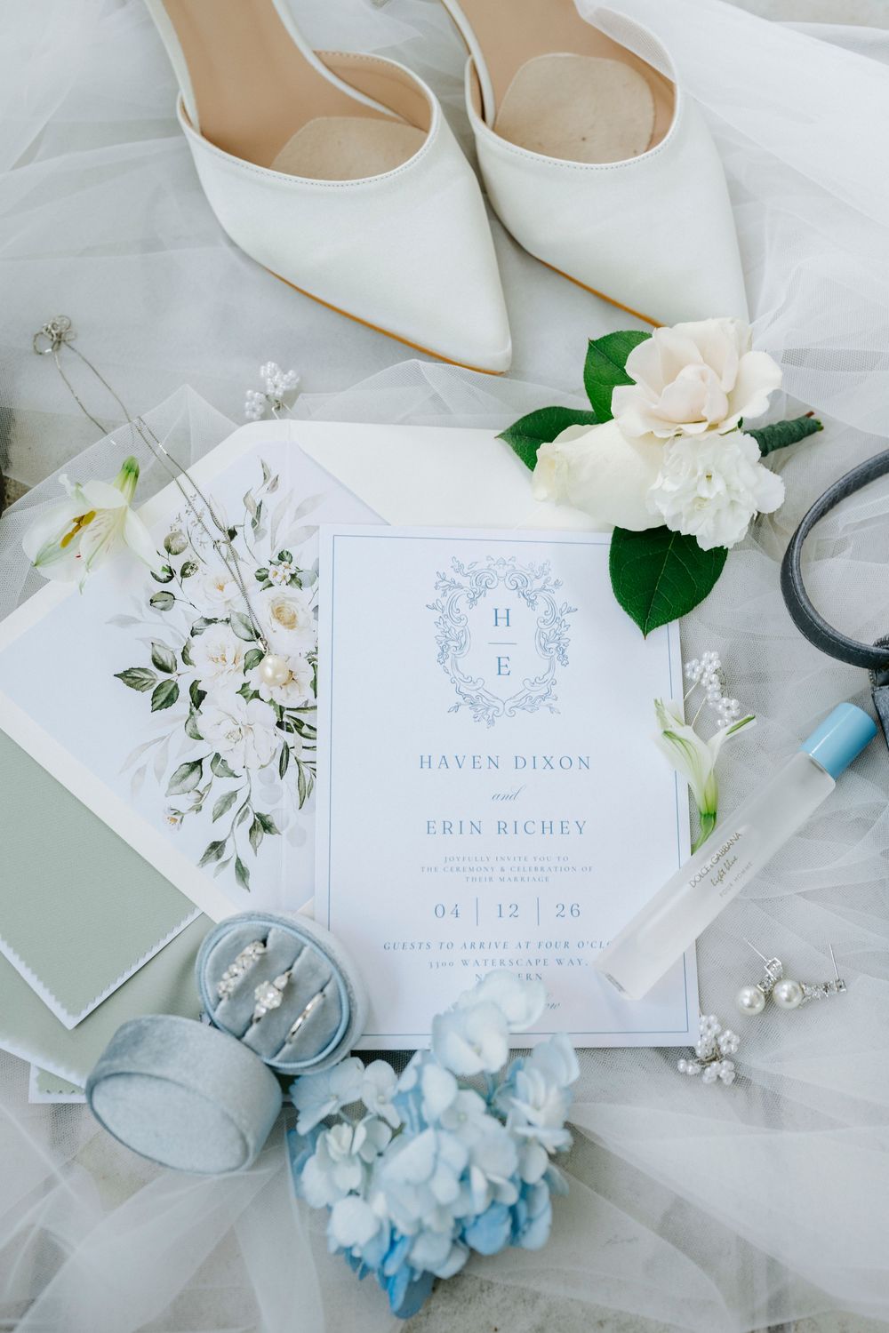 Elegant wedding flat lay with ivory heels, floral invitation for Haven Dixon and Erin Richey, blue hydrangeas, and pearl jewelry.