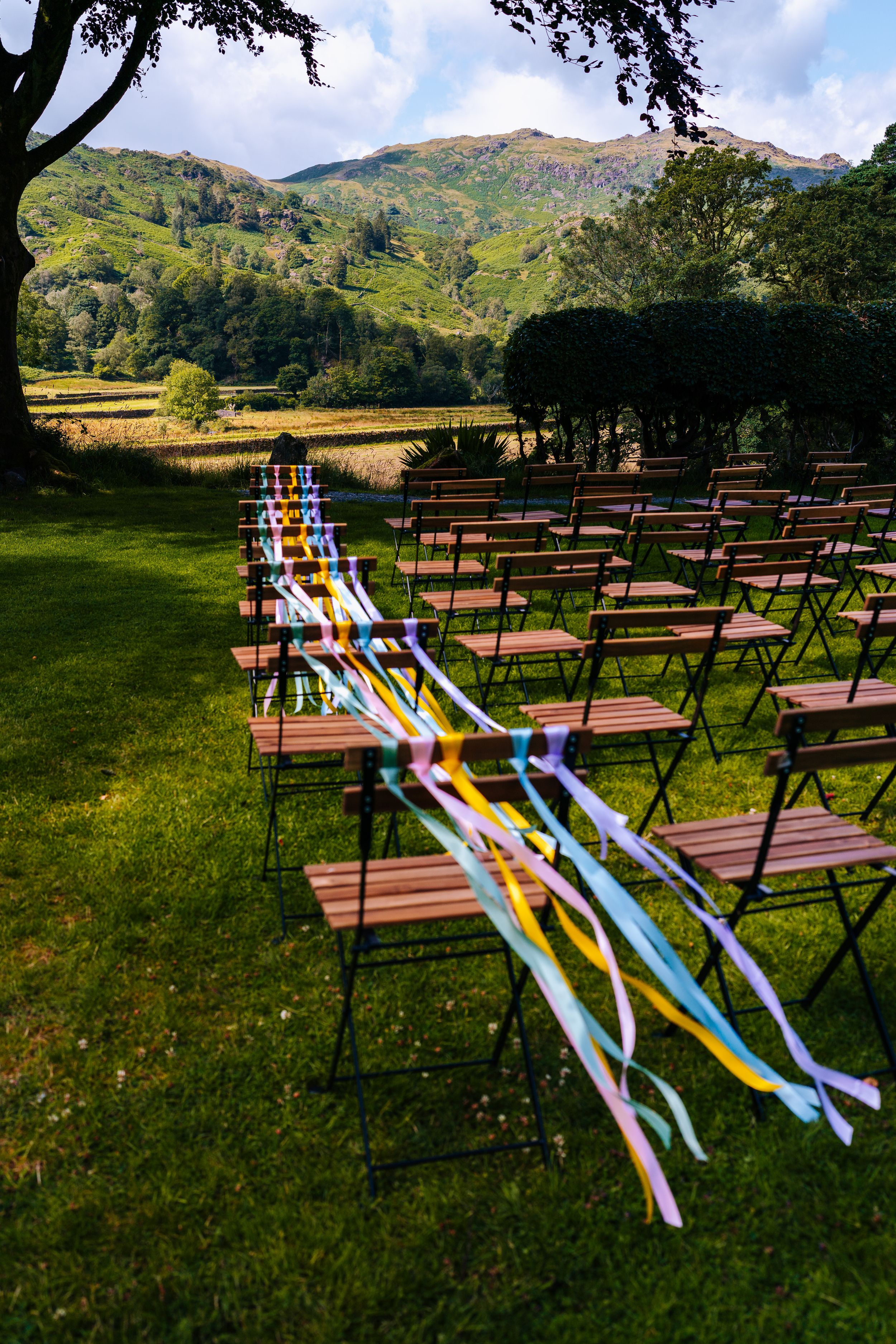 Colourful wedding ribbons on chairs for outdoor ceremony at the Lancrigg