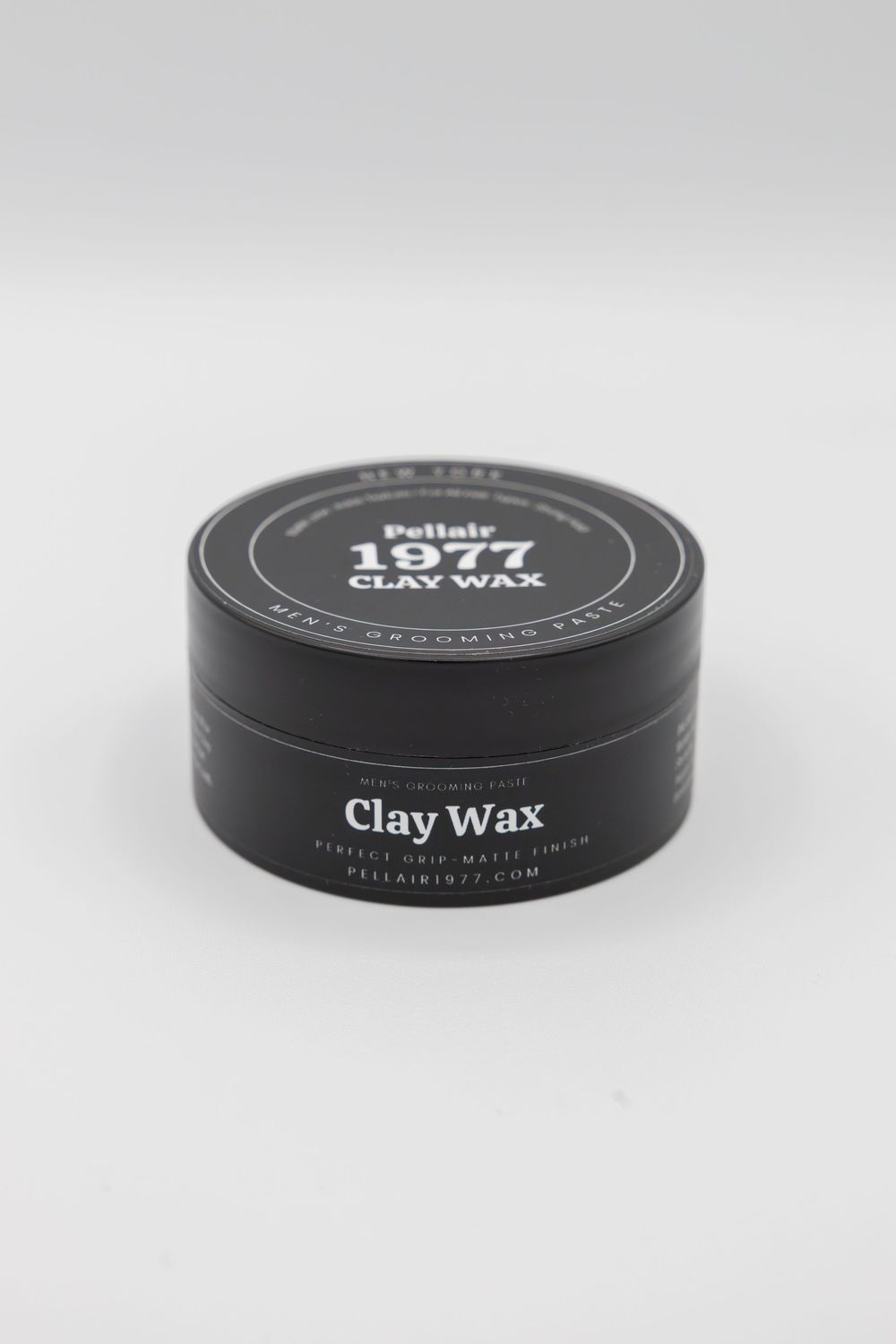 Pollair 1977 Clay Wax men's grooming paste in a sleek black round tin with matte finish label.