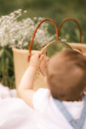 Wicker basket with delicate white flowers against blurred outdoor background.