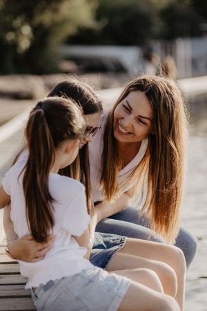 Two people sharing a joyful moment while sitting outdoors in casual clothing.