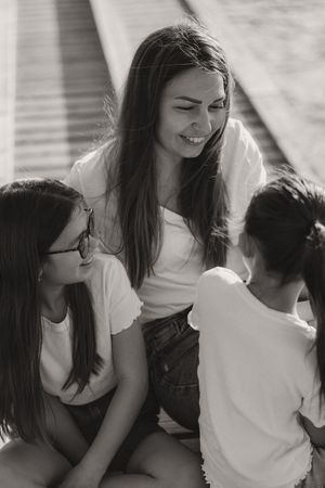 Candid black and white shot of three people sharing laughter while sitting together.