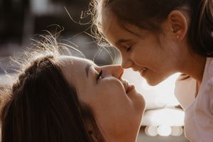 Intimate backlit portrait capturing tender moment at golden hour.