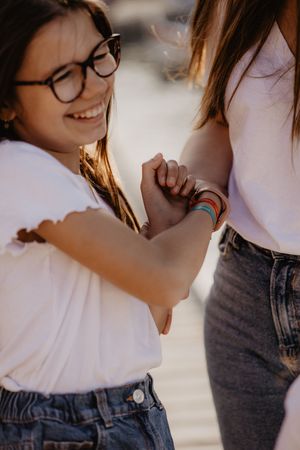Candid moment showing two friends in white shirts and denim sharing genuine laughter.