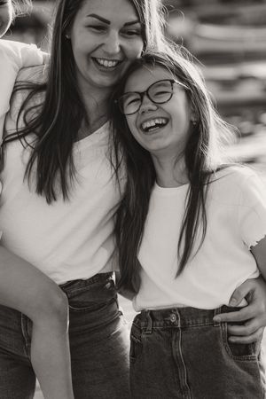 Two friends in casual white shirts and denim laughing together in a candid sequence of photos.