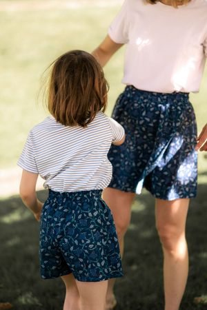 Matching outfits of floral shorts and t-shirts worn in summer garden setting.