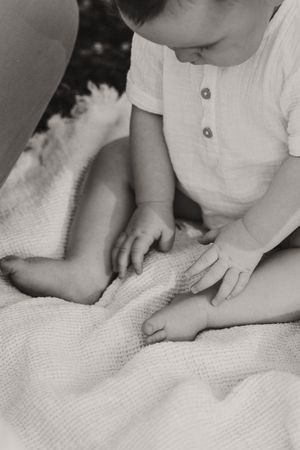 Black and white image showing gentle touches and interaction on textured fabric.