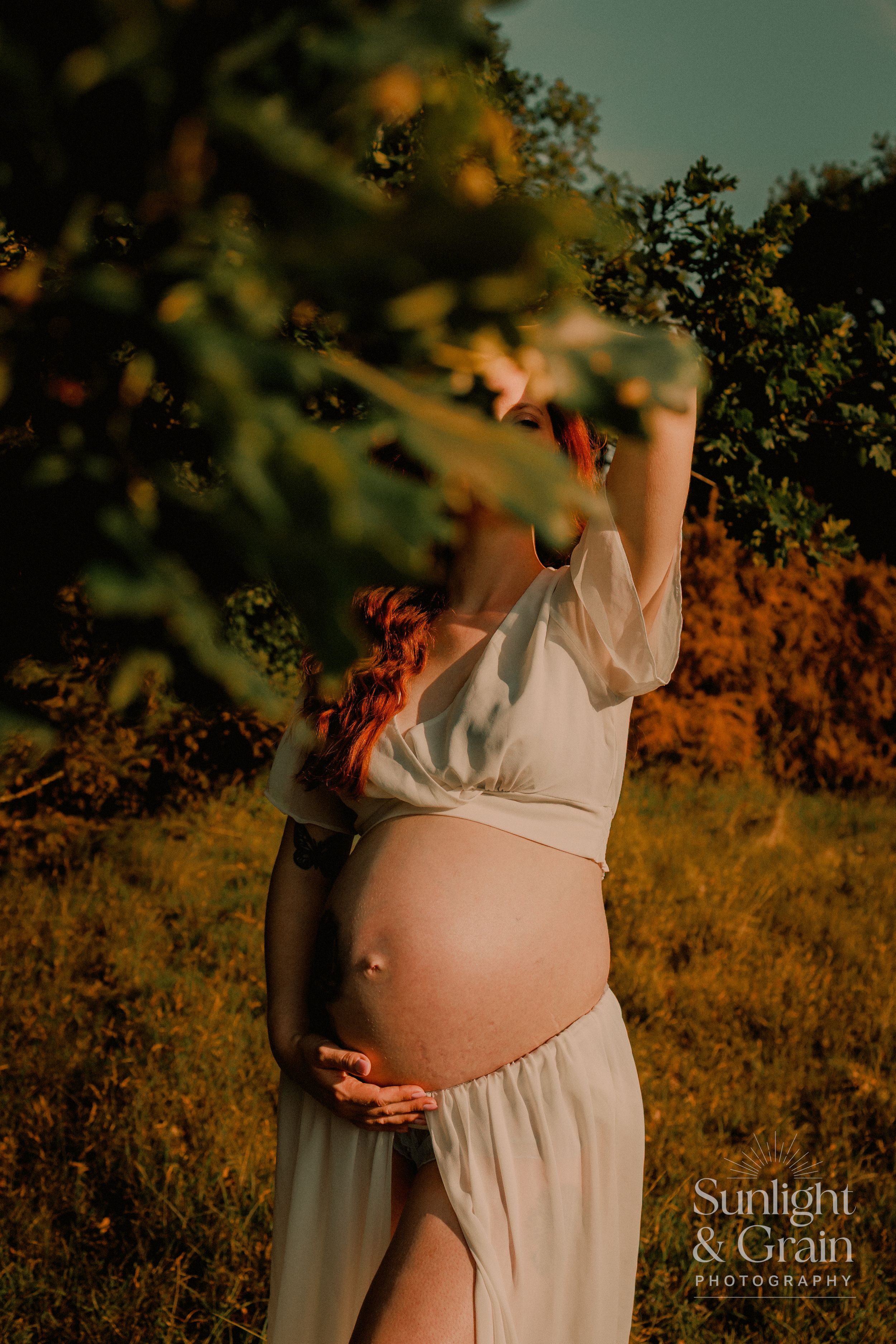 Outdoor maternity soulful, natural light, colourful, lady holding bump, while in-between the leaves, Thetford, female empowerment session