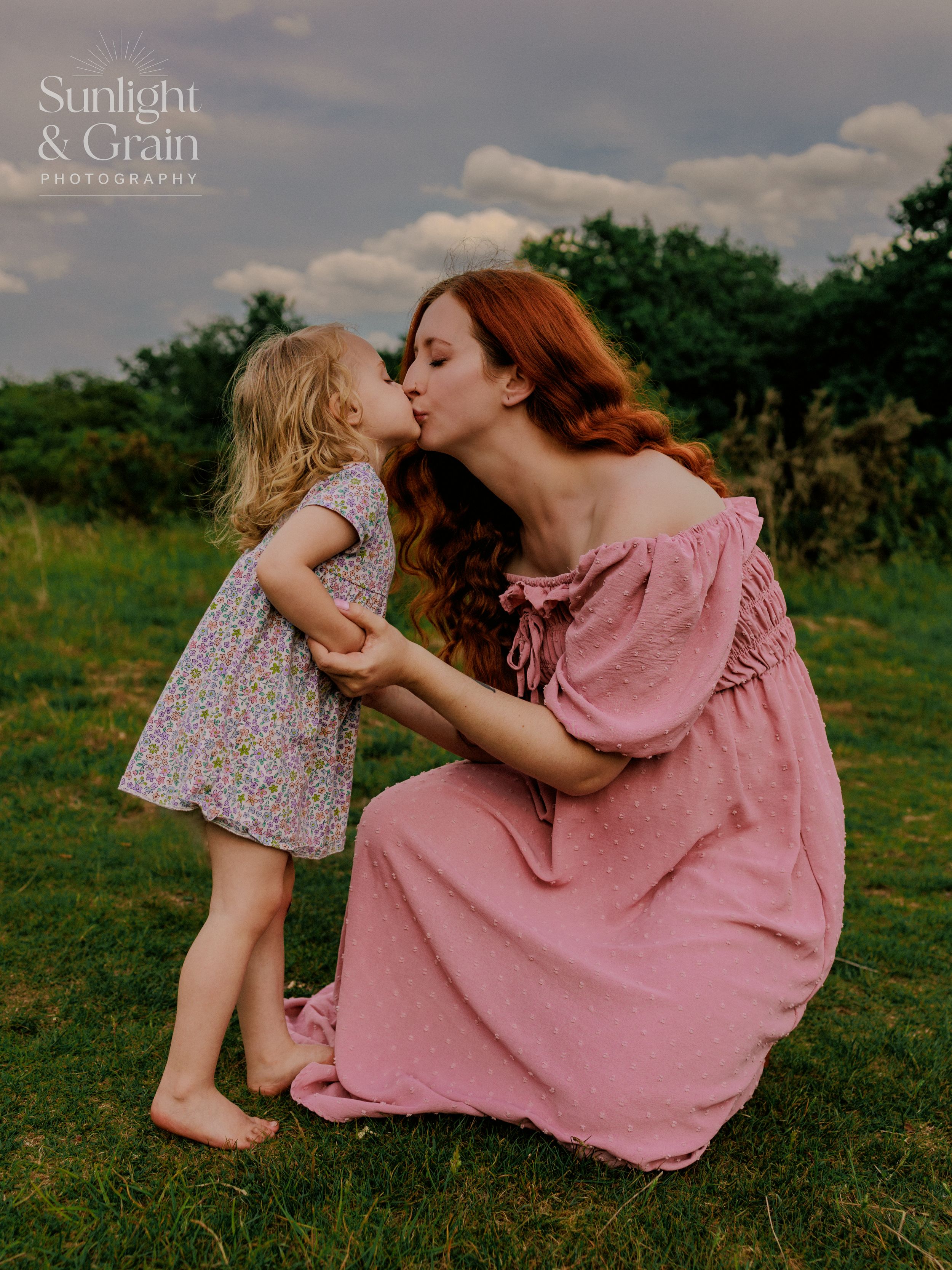 Outdoor maternity soulful, natural light, colourful, sharing kiss with her toddler ,sweet, tender, motherhood photography Thetford