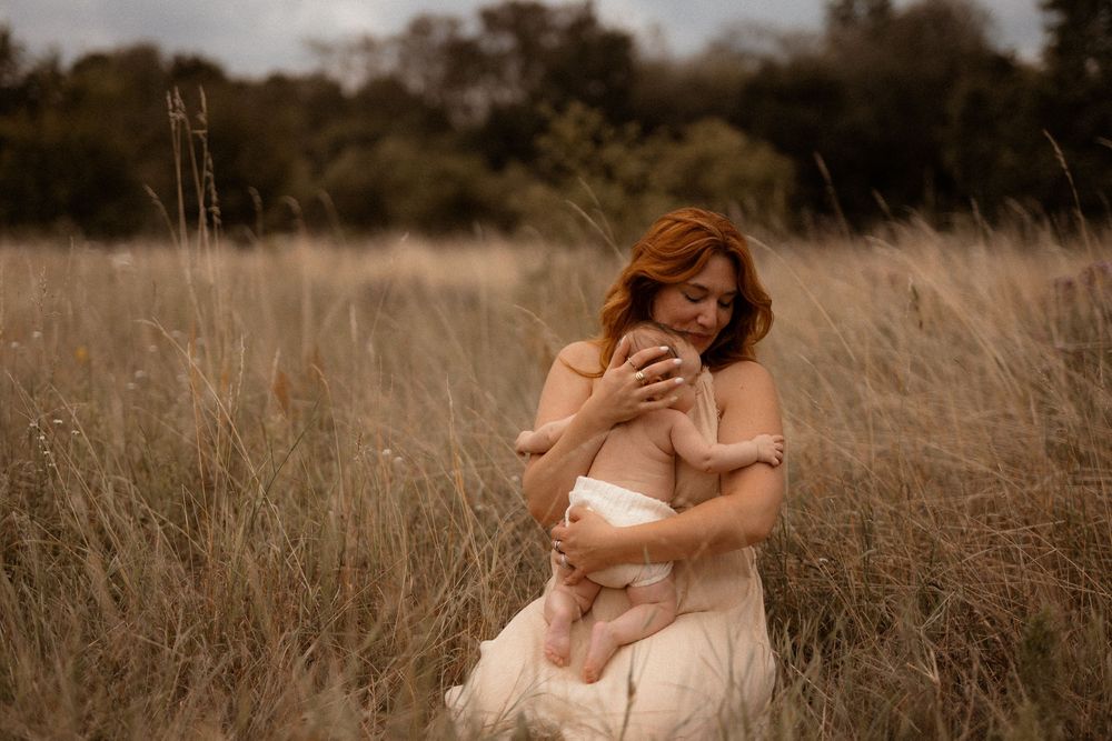 Romantic couple embraces and kisses in a golden autumn field during sunset.
