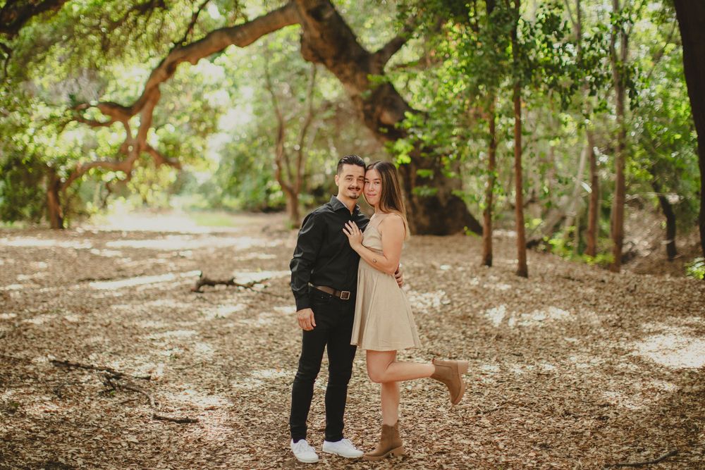 Romantic couple photos in a natural wooded setting with filtered sunlight.