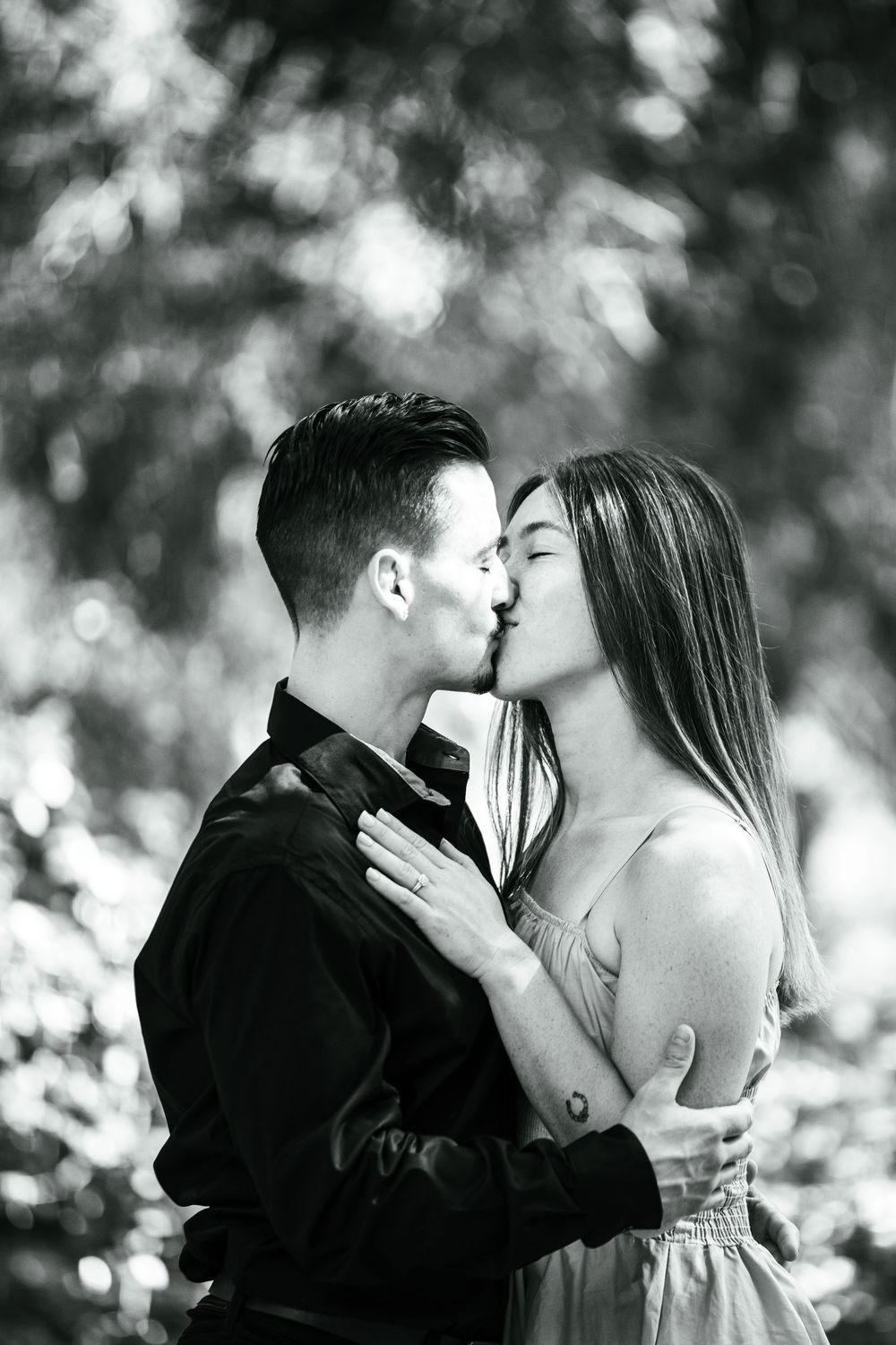 Black and white romantic portraits of couple embracing outdoors.