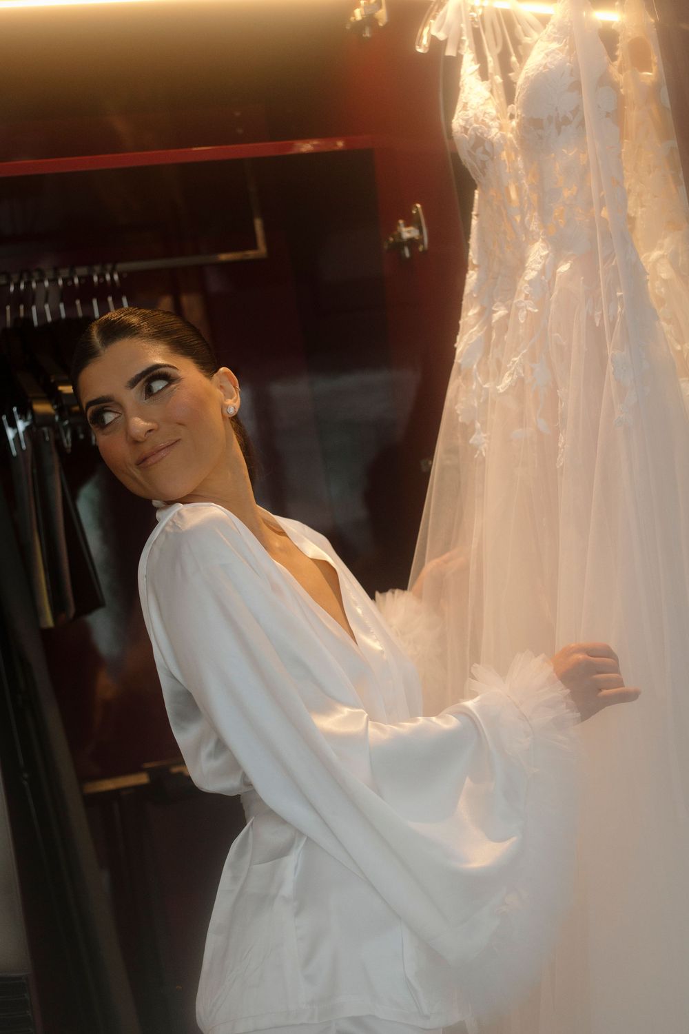 White bridal robe and veil preparation scene in warm lighting.