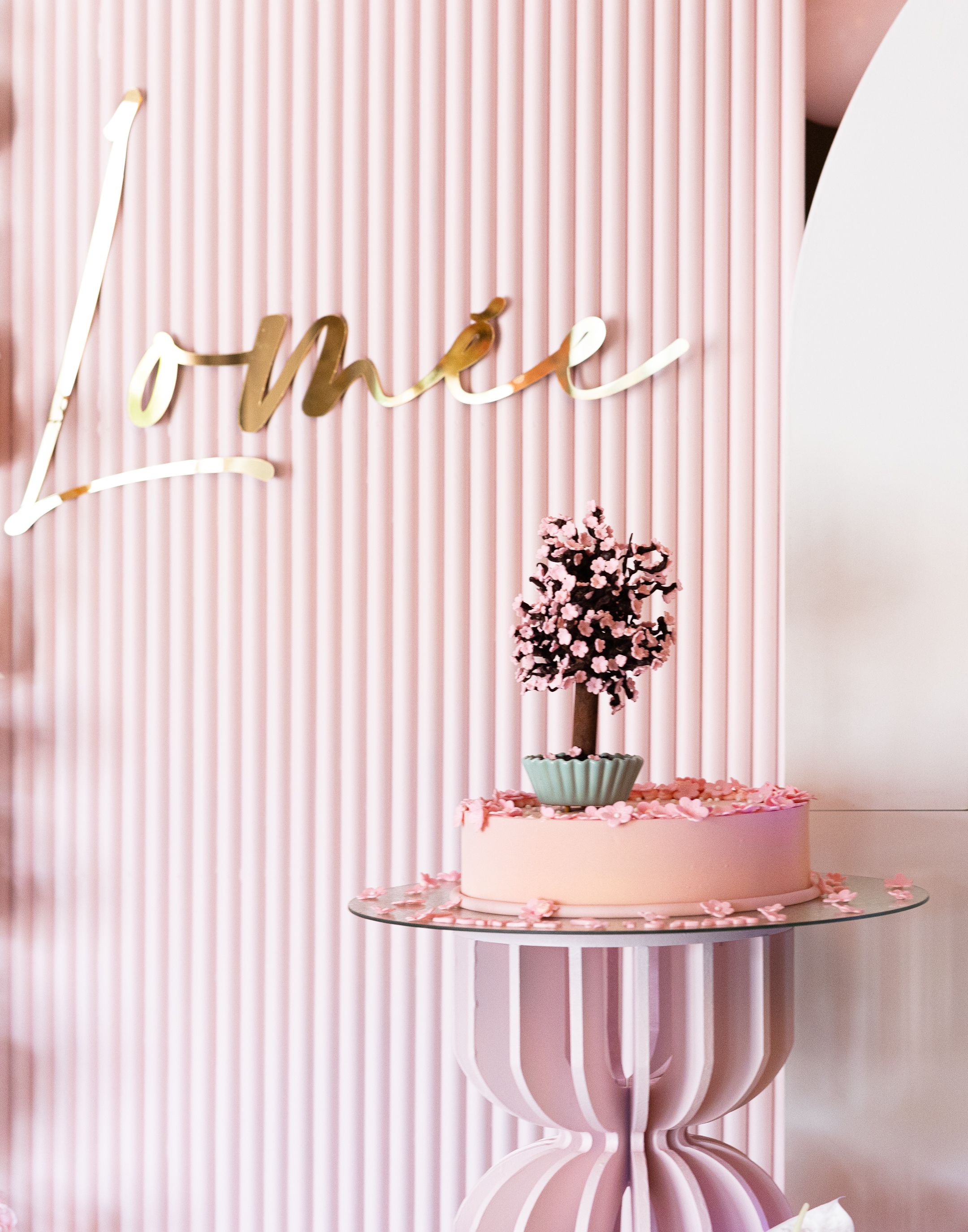 Pink and white striped background with a decorative cake stand and delicate floral details.