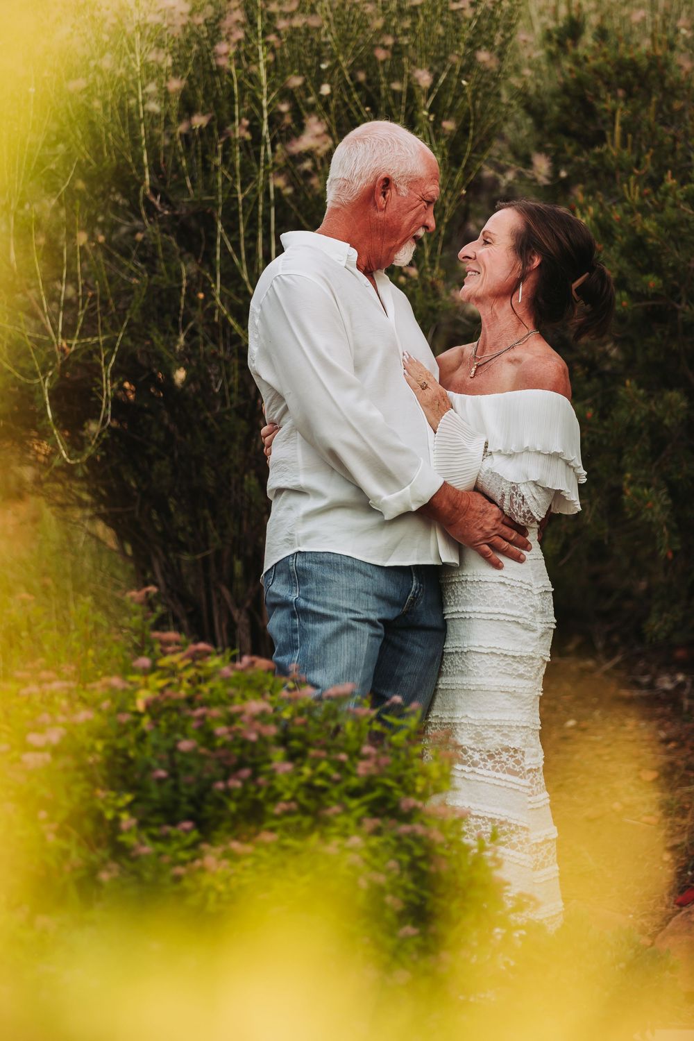 A couple shares tender moments together during a romantic garden photoshoot in warm evening light.