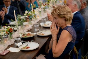 Guest reacts with joy during an emotional moment at an elegant outdoor wedding reception.