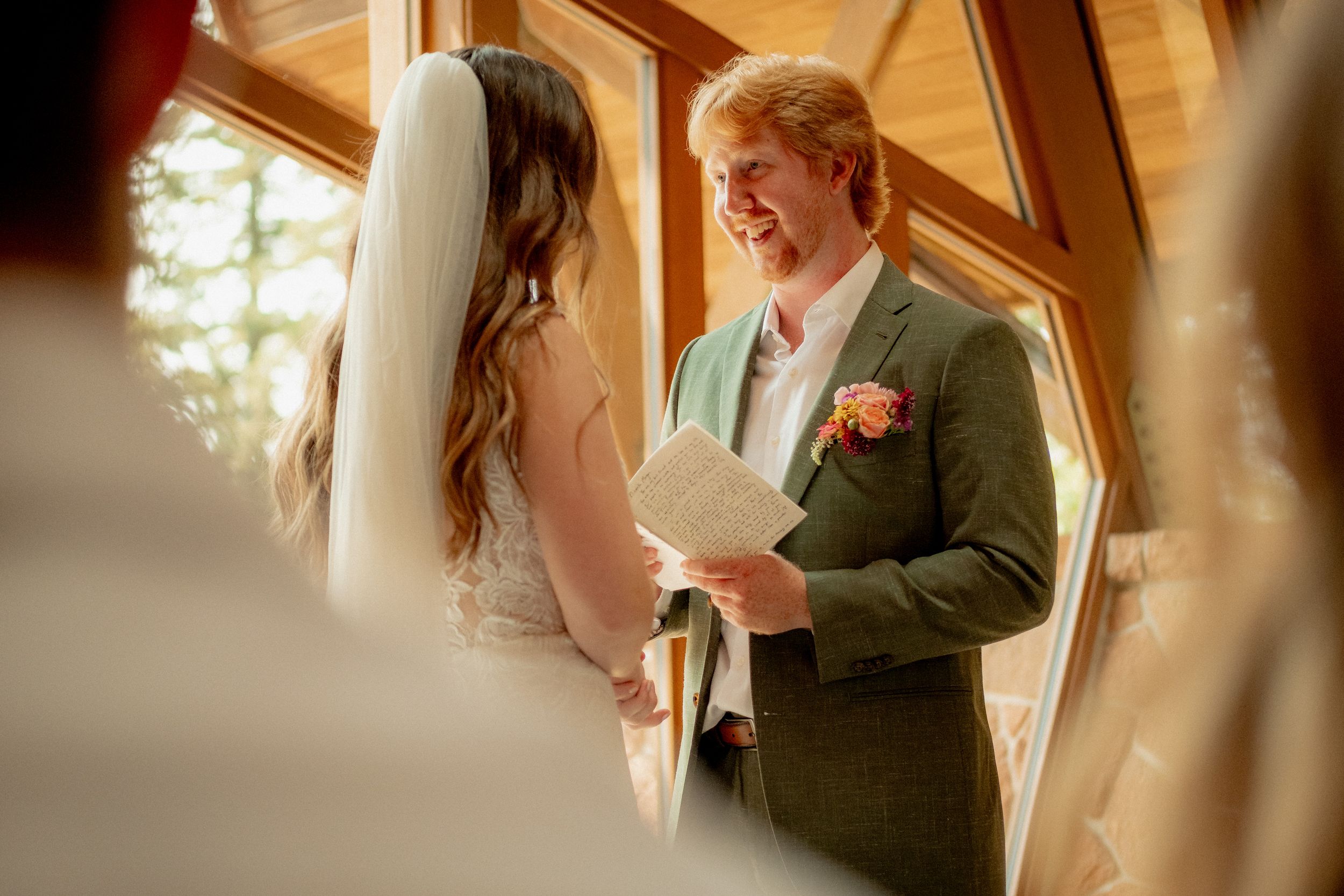 Couple shares intimate moment while reading vows during wedding ceremony.