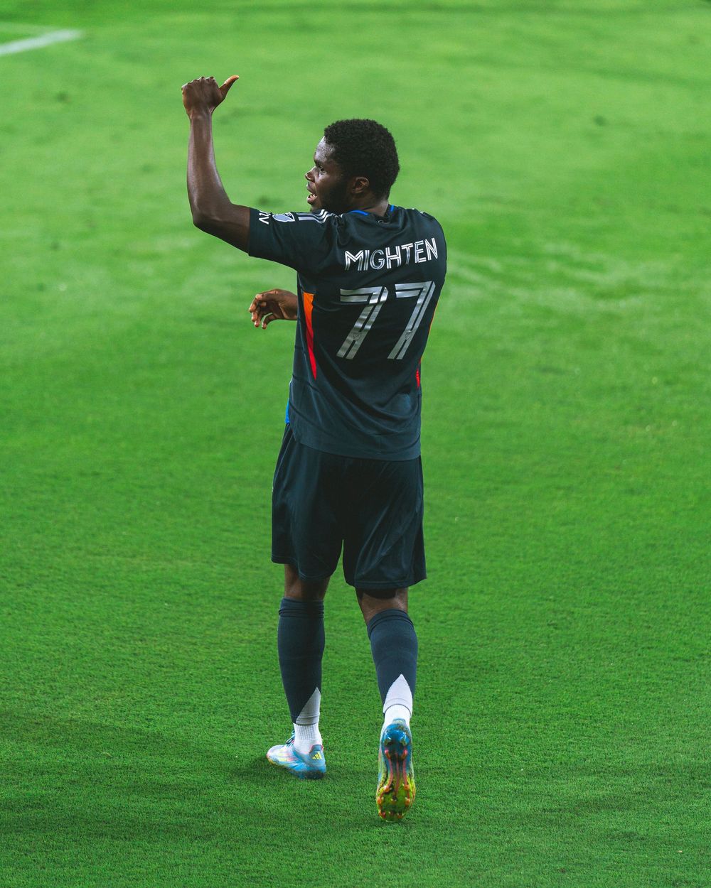 A soccer player gives a thumbs up to the fans