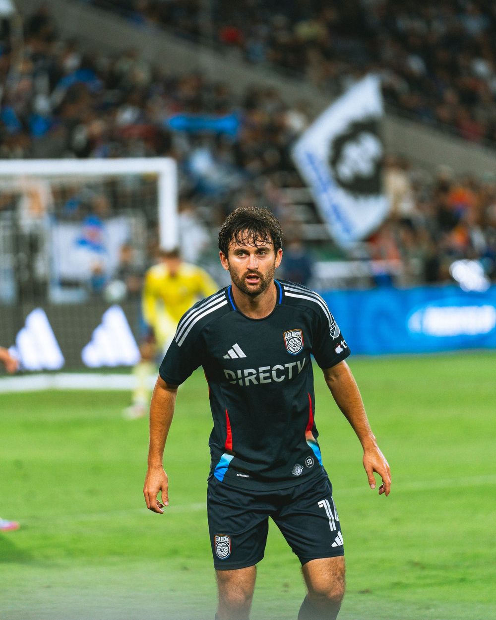 A soccer player stands waiting for a ball