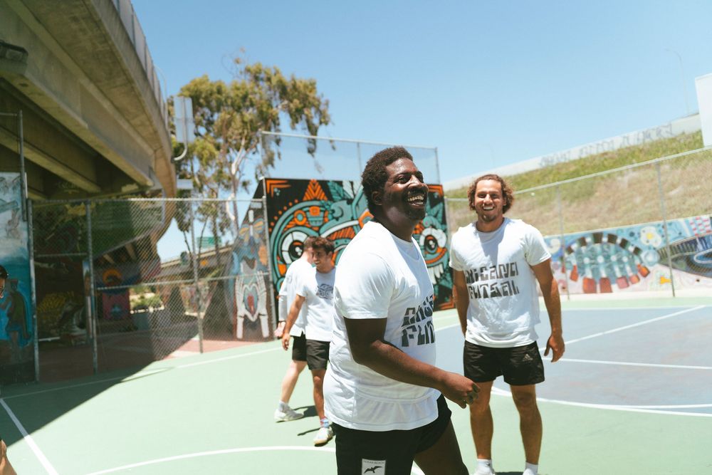 A man smiles on a basketball court