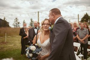 Wedding guests gather outdoors under string lights during an evening celebration.