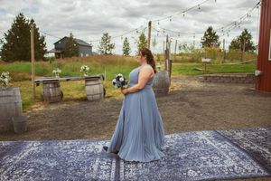 String lights hang over a patterned dance floor at an outdoor venue with mountain views.