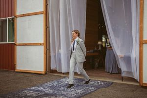 White curtains blow dramatically in the wind against a rustic red barn backdrop creating an ethereal outdoor scene.