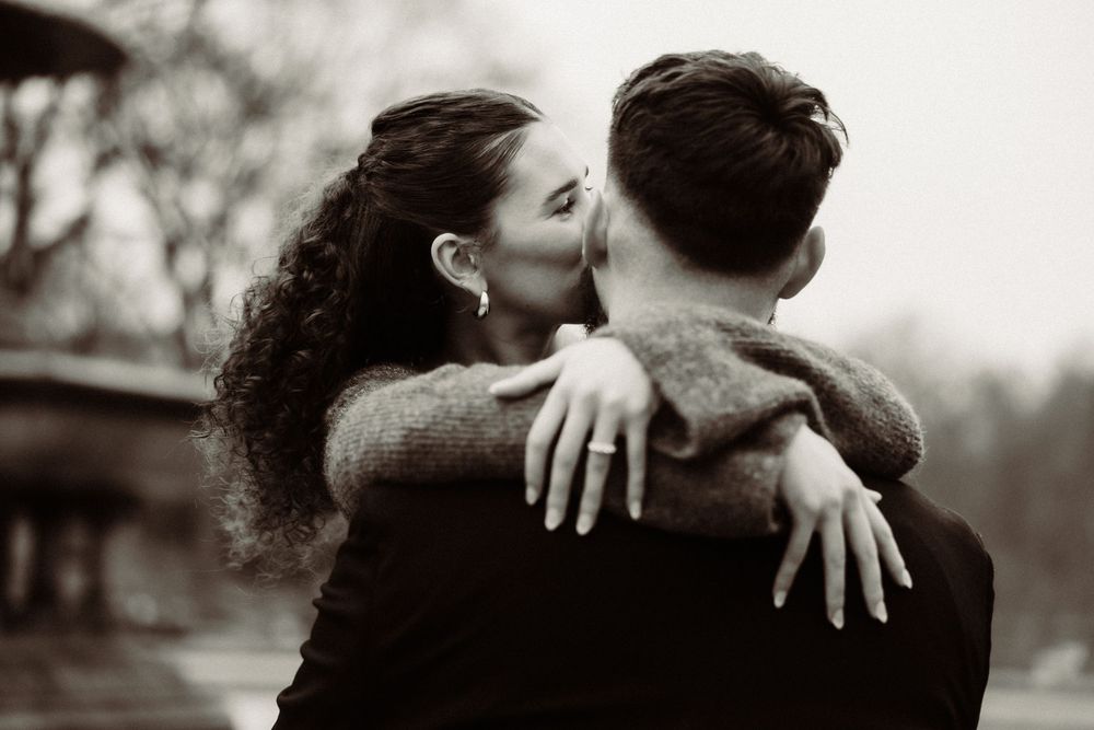 Black and white romantic photo of a loving embrace captured from behind.