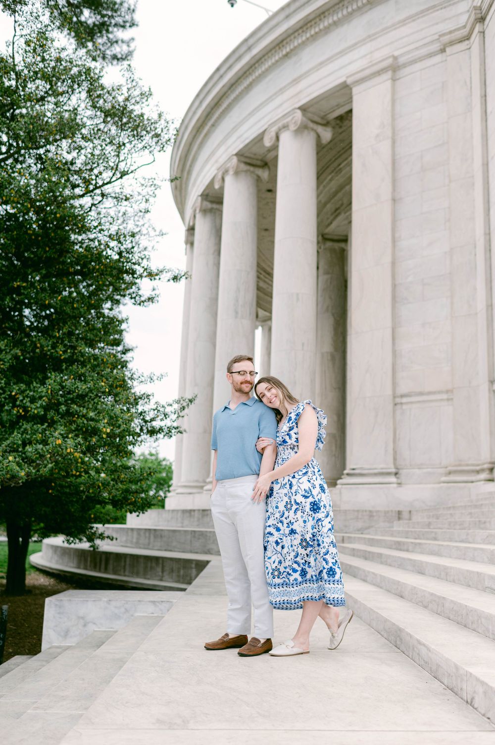 A couple relaxes at the Jefferson Memorial with its iconic columns and architecture.