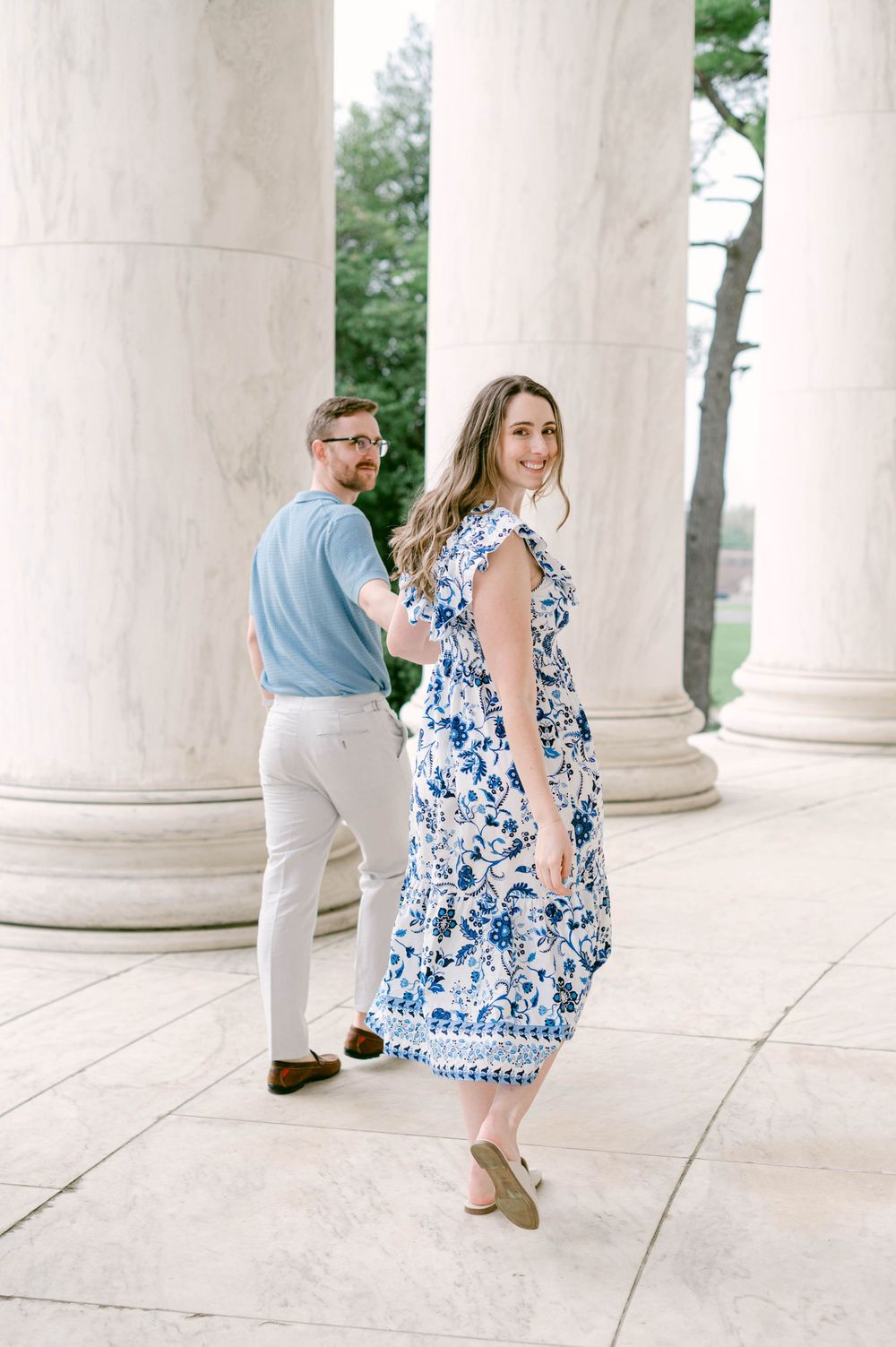 A playful posed shot between classical columns in coordinated spring outfits.